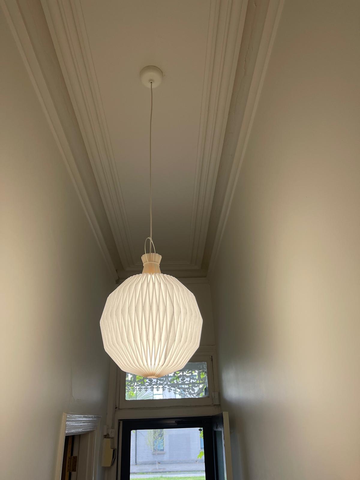 Pendant light installed in a heritage hallway with ornate cornices